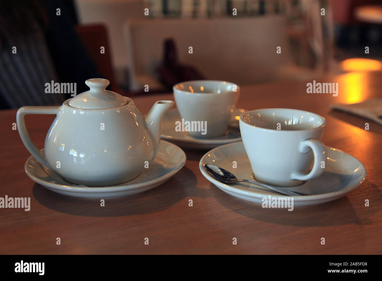 Thé pour deux. Сeramic Théière et tasses (boules) avec du thé chaud parfumé sur fond flou. Table de fête du Nouvel An dans un petit café Banque D'Images