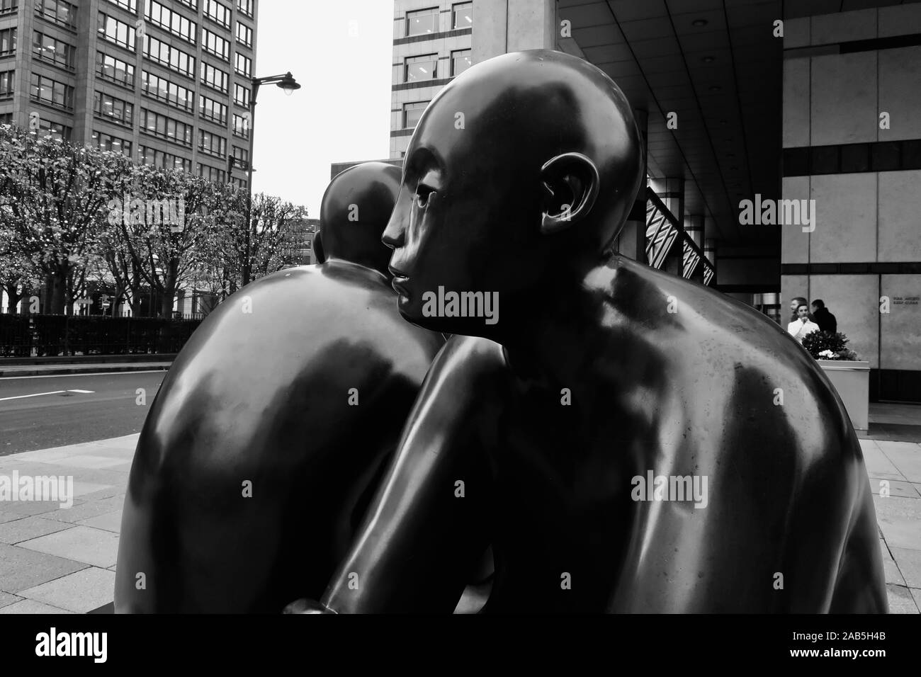 Canary Wharf, London, UK - 22 novembre 2019 : deux hommes sur un banc par Giles Penny. Banque D'Images