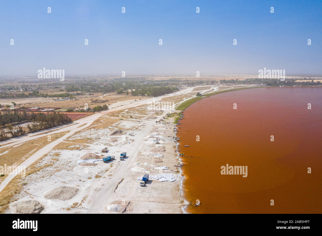 Vue aérienne de petits bateaux pour la collecte du sel au Lac Rose Lac Retba ou Lac Rose au Sénégal. Photo faite par drone depuis au-dessus. Le paysage naturel de l'Afrique Banque D'Images