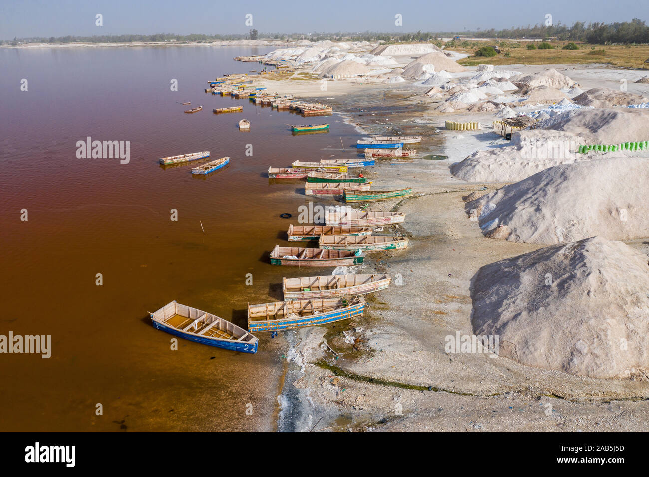 Vue aérienne de petits bateaux pour la collecte du sel au Lac Rose Lac Retba ou Lac Rose au Sénégal. Photo faite par drone depuis au-dessus. Le paysage naturel de l'Afrique Banque D'Images