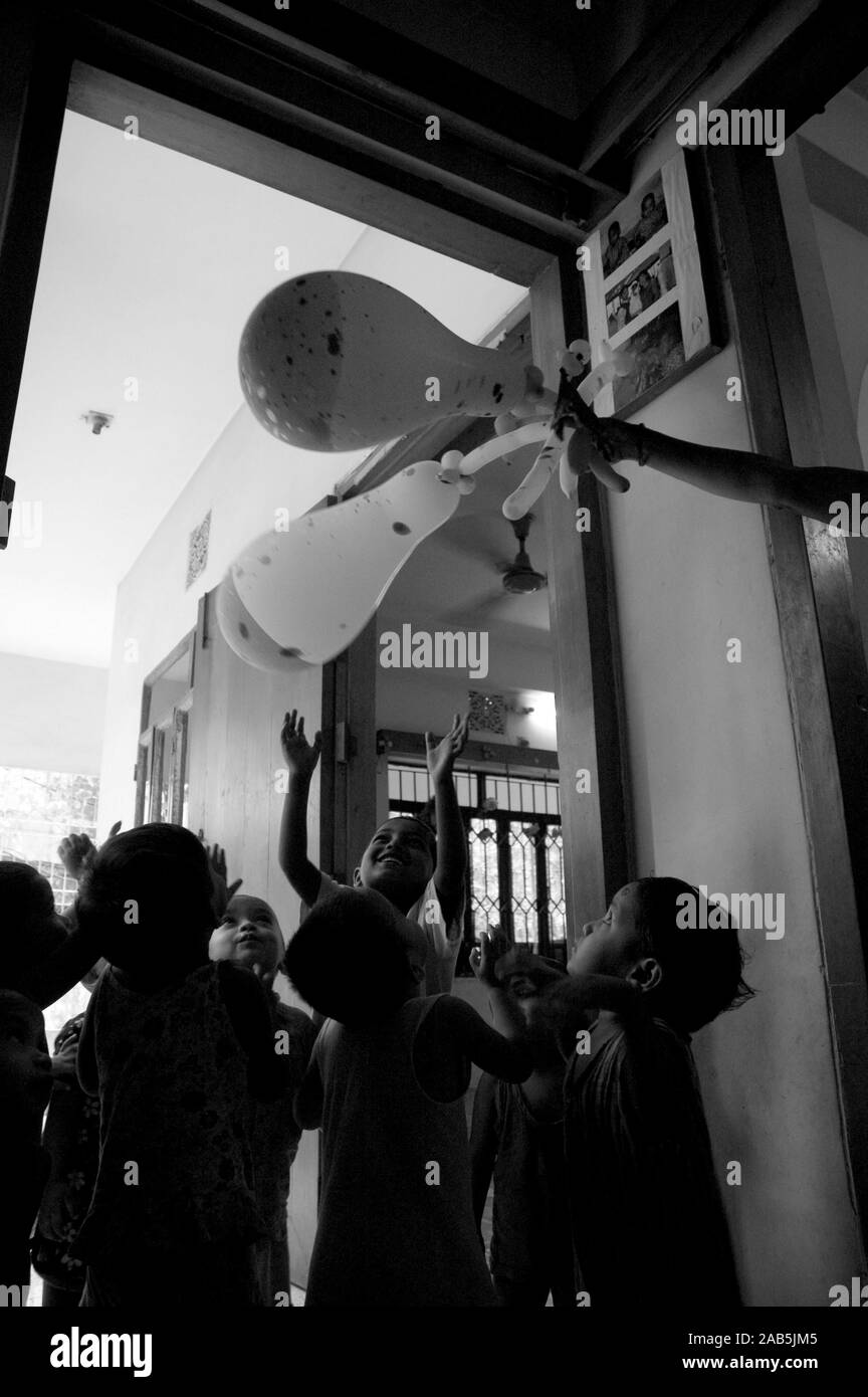 Une ayah, infirmière ou femme de chambre, offrez-vous les enfants d'un peu de plaisir avec des ballons. Dhaka, Bangladesh. Le 11 mai 2007. Banque D'Images