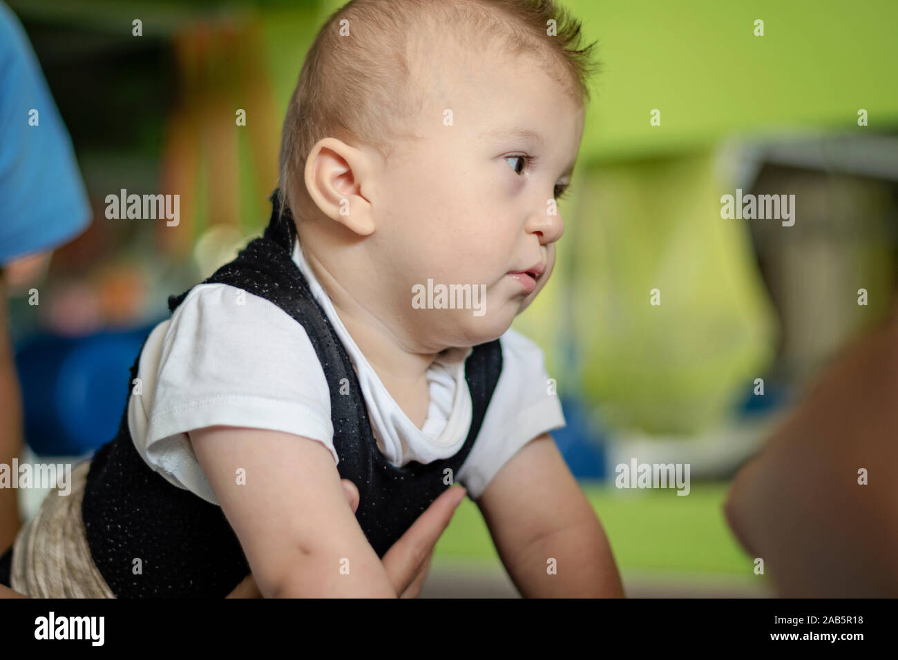 Portrait d'un bébé souffrant de paralysie cérébrale sur la physiothérapie dans un centre de thérapie pour enfants. Garçon avec handicap a la thérapie en faisant des exercices. Petit Enfant Banque D'Images