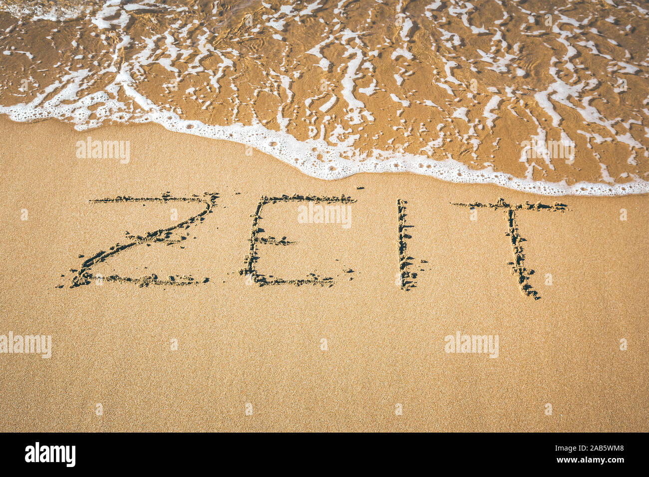 Ein Sandstrand, auf dem 'Zeit' geschrieben steht. Banque D'Images