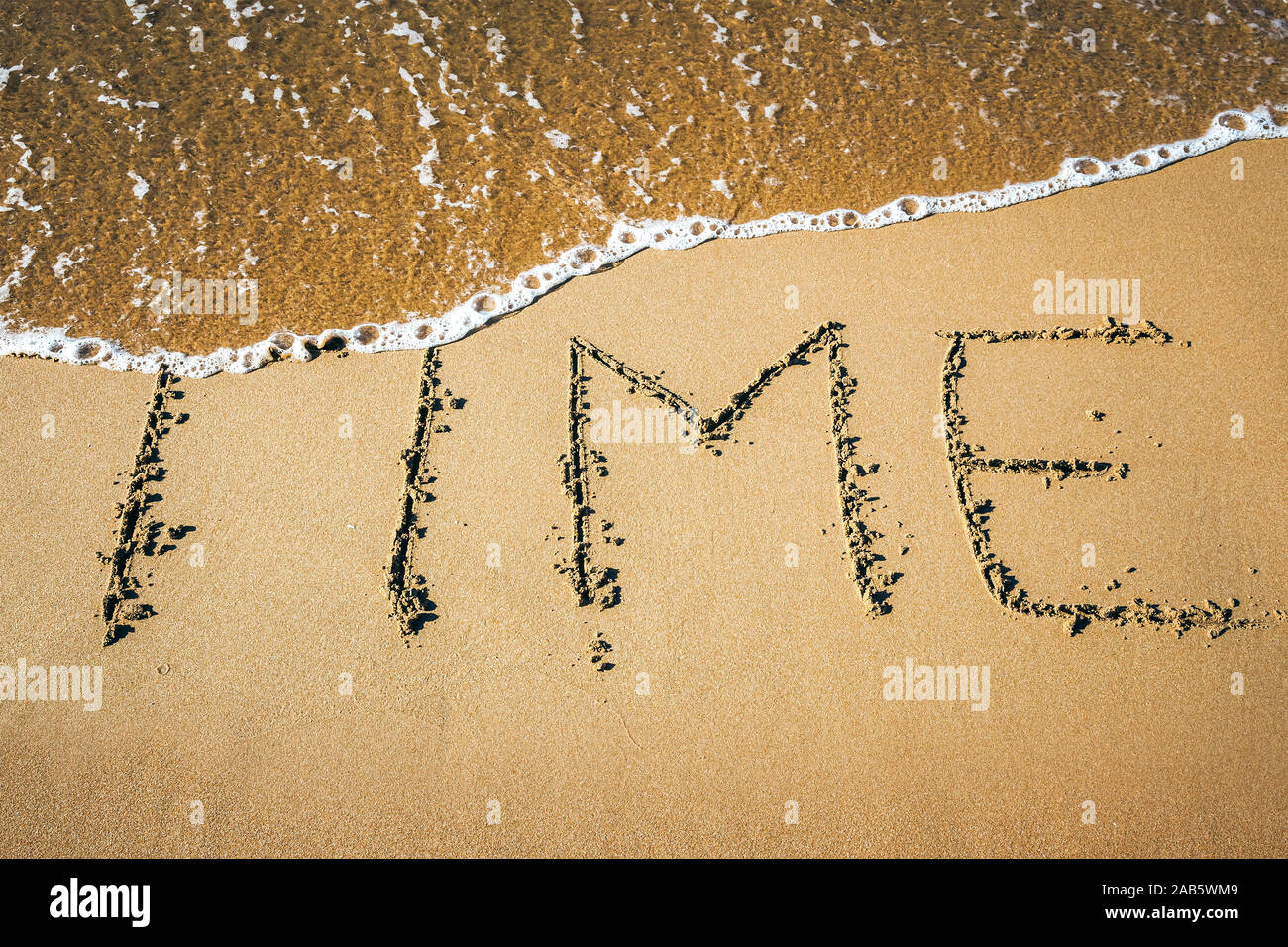 Ein Sandstrand, auf dem 'Temps' geschrieben steht. Banque D'Images