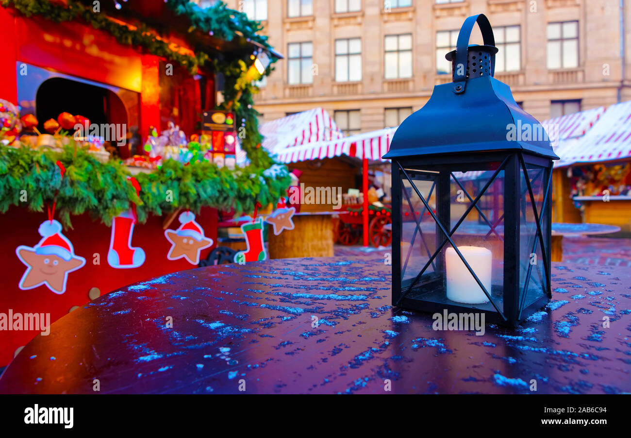 Lanterne avec une bougie allumée sur une table à la foire de Noël à Riga reflex Banque D'Images