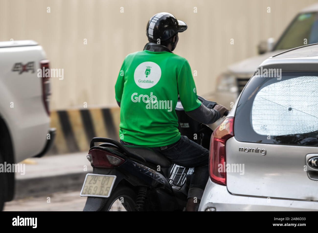 Hanoi, Vietnam - 11 octobre 2019 : Un grab bike rider fléchettes par le trafic de l'appareil photo sur son chemin à son ramassage client suivant Banque D'Images