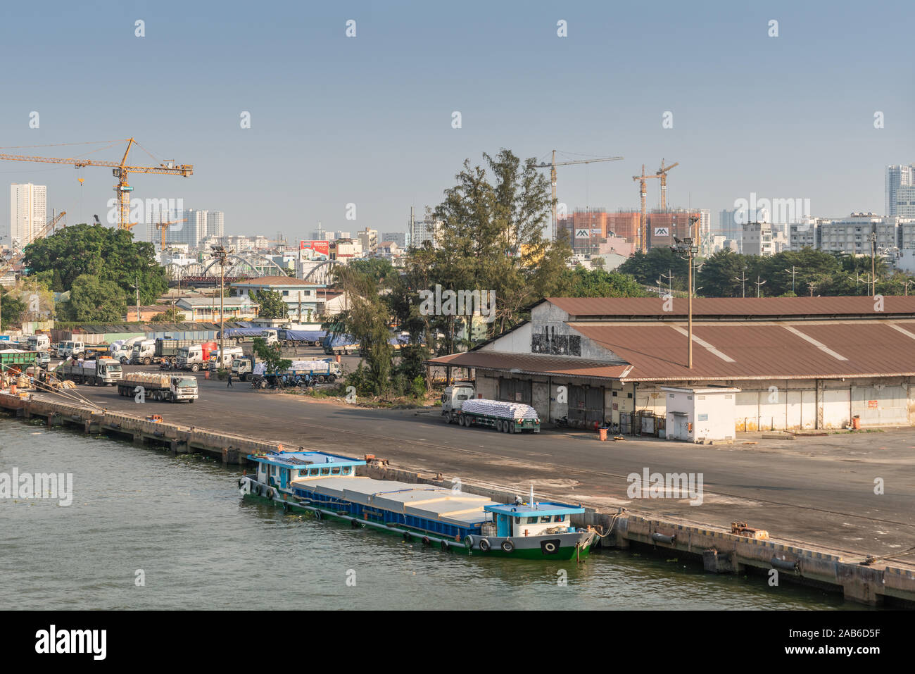 Ho Chi Minh Ville, Vietnam - 13 mars 2019 - Centre-ville de port sur Chanson fleuve Sai Gon au coucher du soleil. Petit chaland moderne bleue à quai près de l'entrepôt où truck Banque D'Images