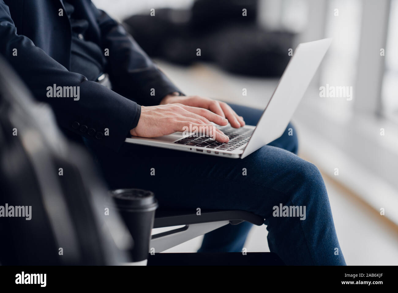 Close up of young stage business man mains tapant sur un clavier d'ordinateur portable tout en travaillant à distance. Banque D'Images
