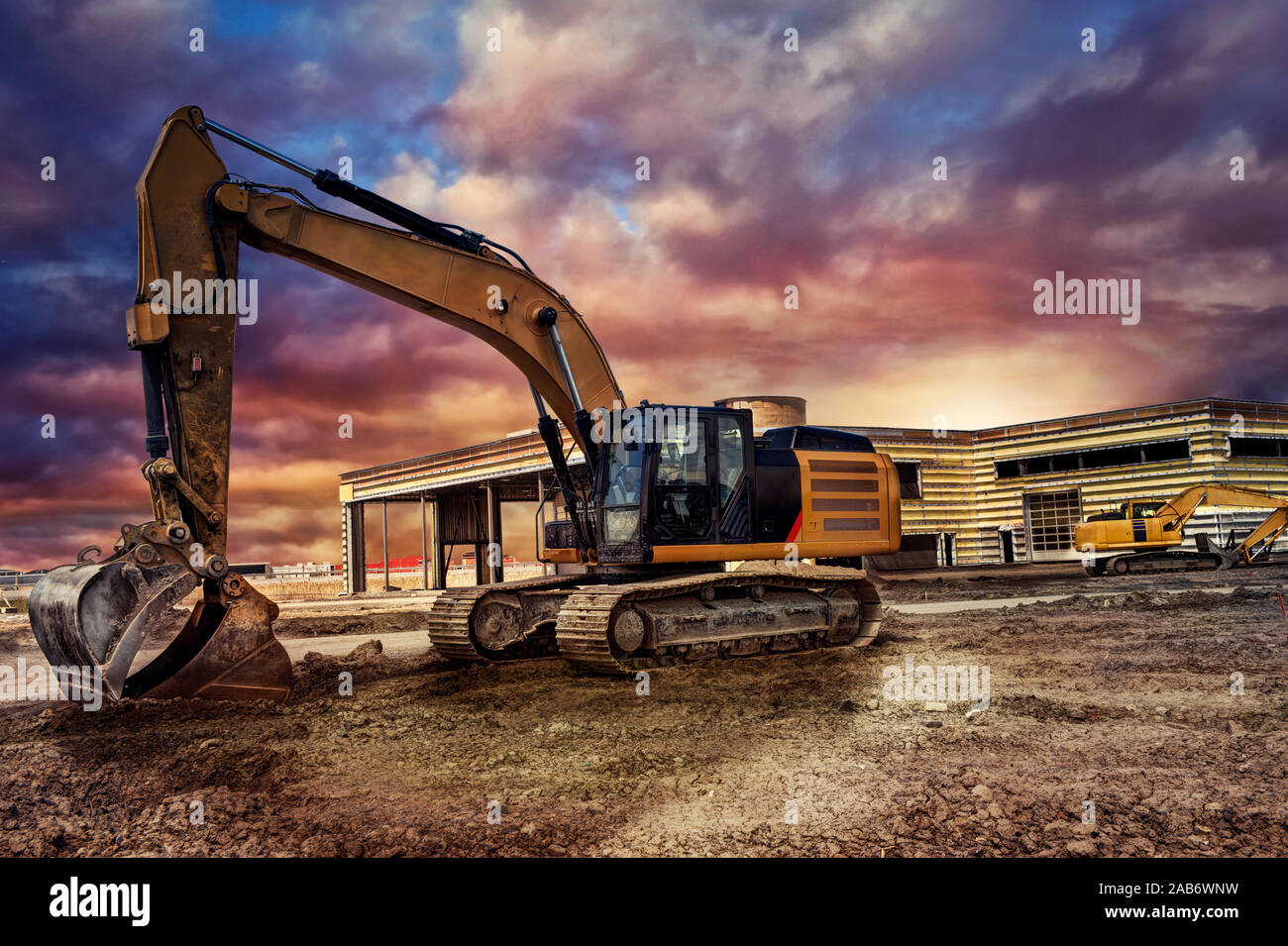 Machines d'excavation sur le site de construction, coucher de soleil en arrière-plan. Banque D'Images