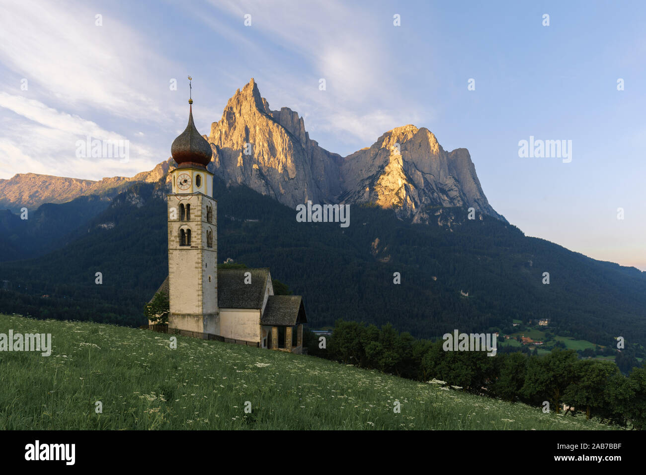 Paysages de Sunrise Eglise Saint Valentin sur une colline herbeuse avec vue sur pics accidentés de la montagne Schlern avec alpenglow en arrière-plan dans la vallée o Banque D'Images