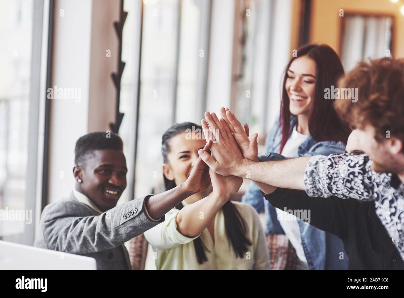 Heureux les jeunes entrepreneurs dans les tenues à cafe table ou bureau d'affaires en offrant un rapport cinq ans à l'autre comme si des succès à célébrer ou à partir Banque D'Images
