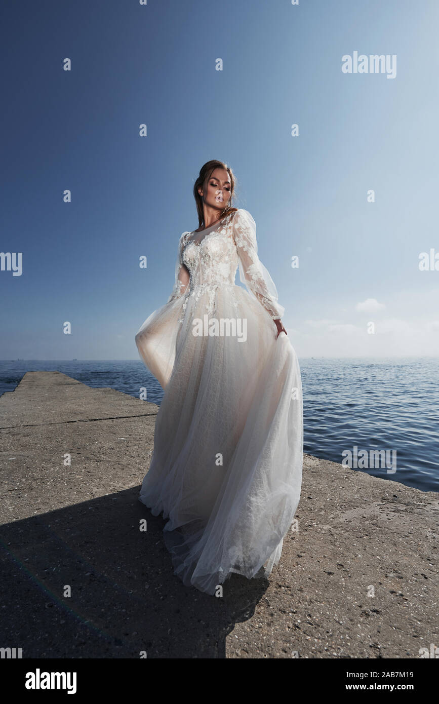 Mariee Dans Une Robe De Mariage Sur La Plage Par La Mer Contre L Arriere Plan D Un Ciel Bleu Photo Stock Alamy