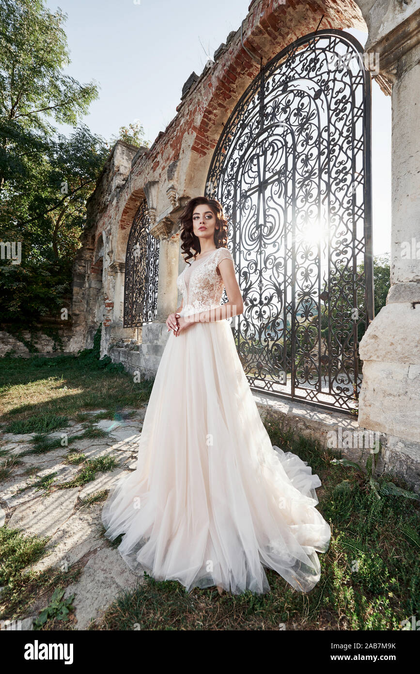 Belle Mariée en robe de mariage, ce qui est photographié le jour du mariage  près de l'ancien château Photo Stock - Alamy