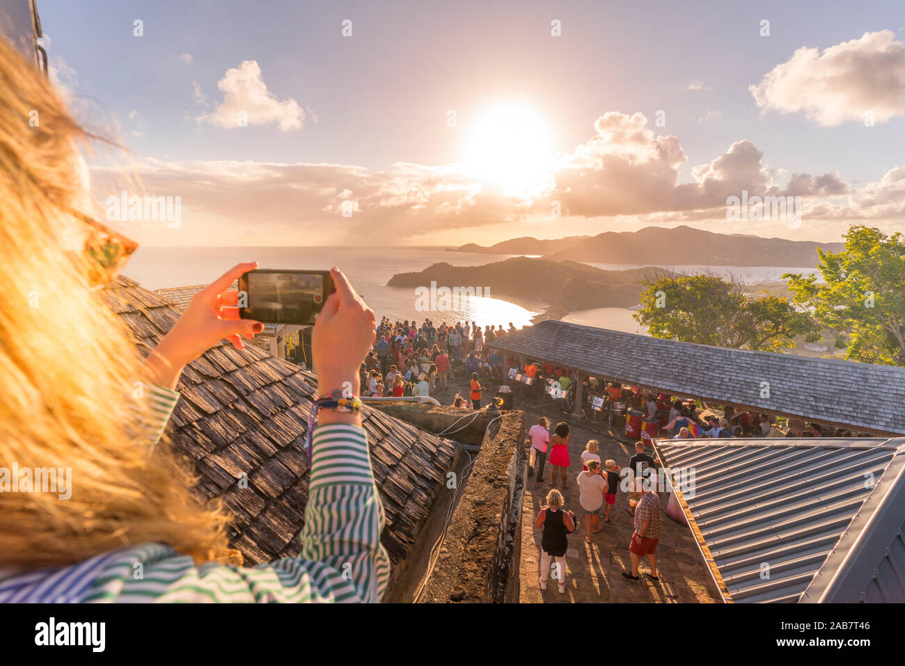 Femme prend des photos avec le smartphone pendant le coucher du soleil, Shirley Heights, Antigua, Antigua-et-Barbuda, Antilles, Caraïbes, Amérique Centrale Banque D'Images