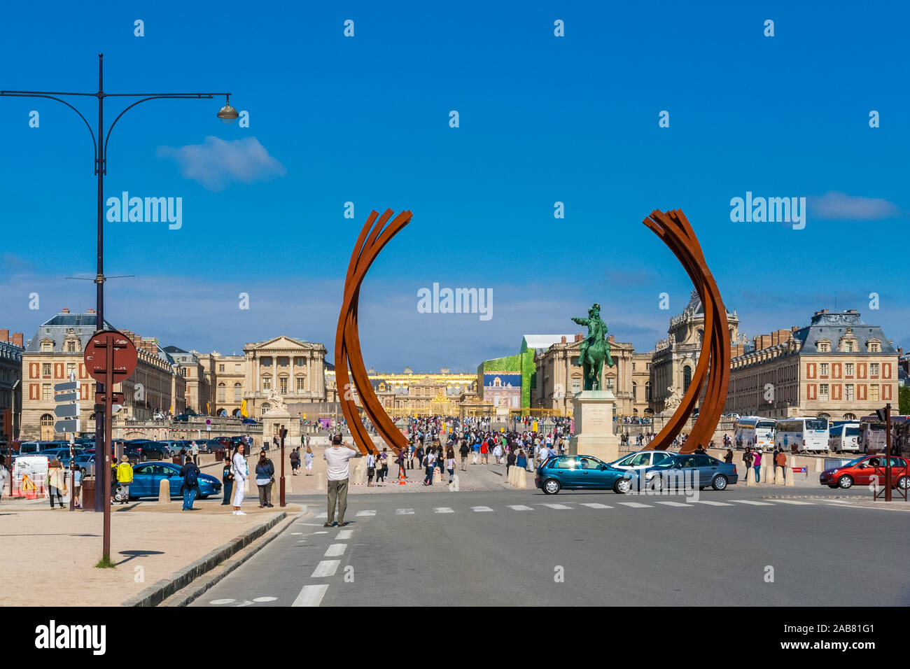 Superbe vue panoramique sur le Château de Versailles avec la sculpture 85.8° Arc x 16 sur la Place d'armes par Bernar Venet. Un homme se tient sur l'Avenue de... Banque D'Images