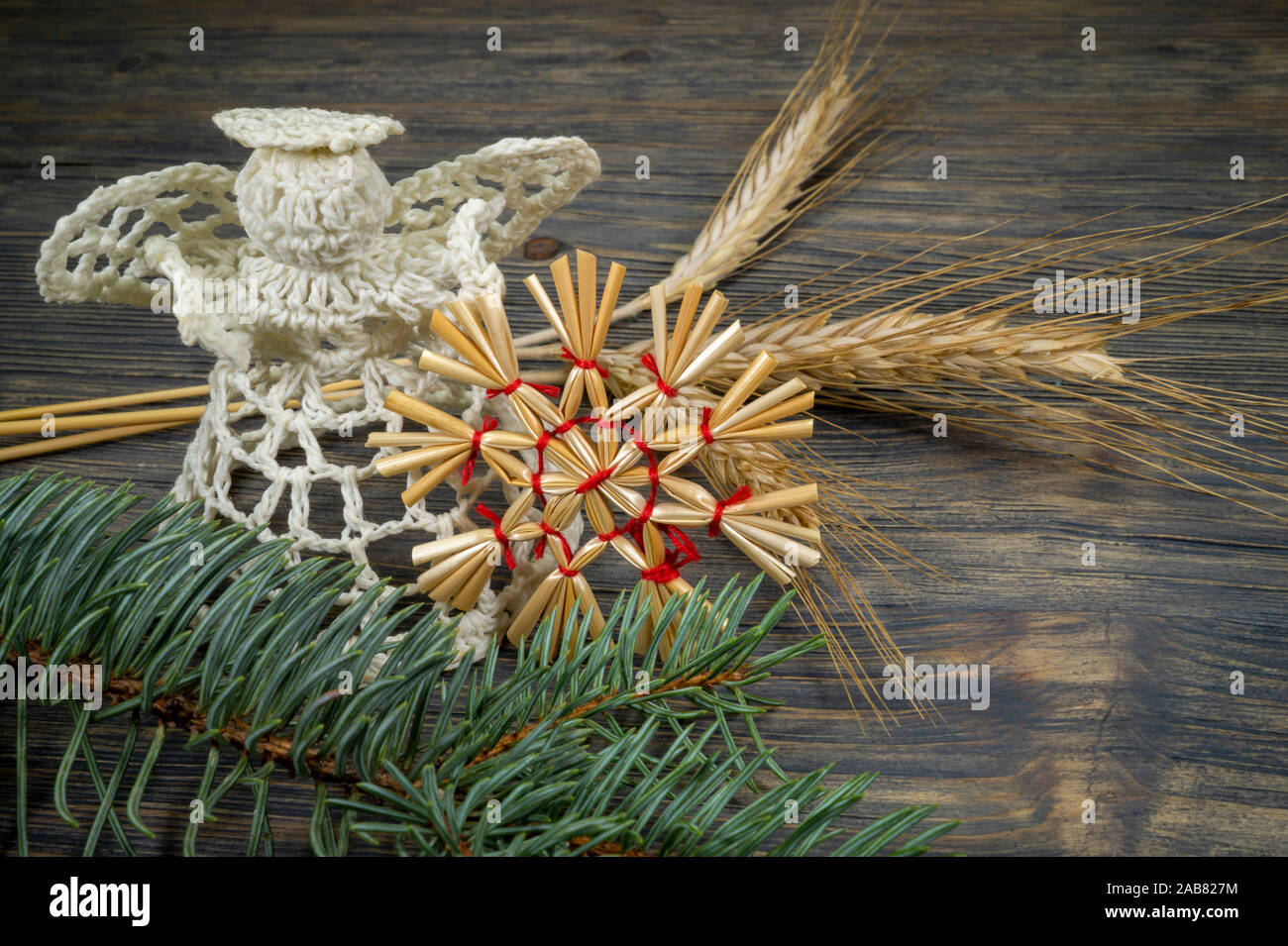 Fond de Noël avec des ornements faits à la main, y compris un ange de bonneterie thread et une paille star attaché avec de la ficelle rouge sur un bois rustique background Banque D'Images