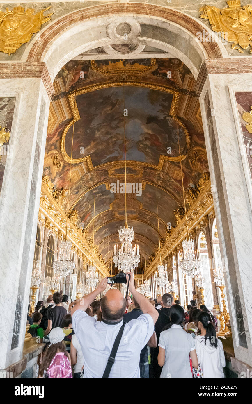 Grande vue portrait d'un homme dans la salle debout à l'entrée voûtée de la célèbre Galerie des Glaces et faire des photos de la belle peint... Banque D'Images