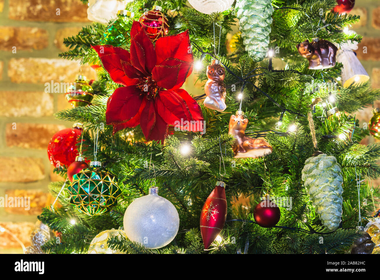 Close up of decorated Christmas Tree, poinsettia, fleur de Noël, guirlandes lumineuses, selective focus Banque D'Images
