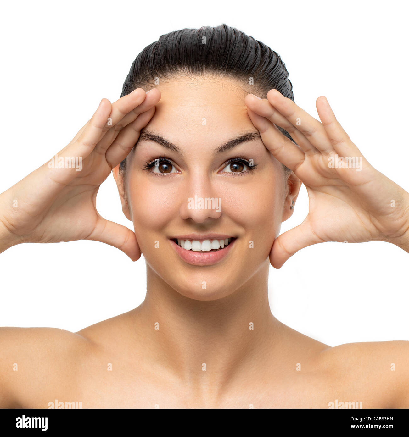 Close up portrait of attractive young woman stretching avec la peau du visage mains.fille aux mains des deux côtés de la face. Isolated on white Banque D'Images