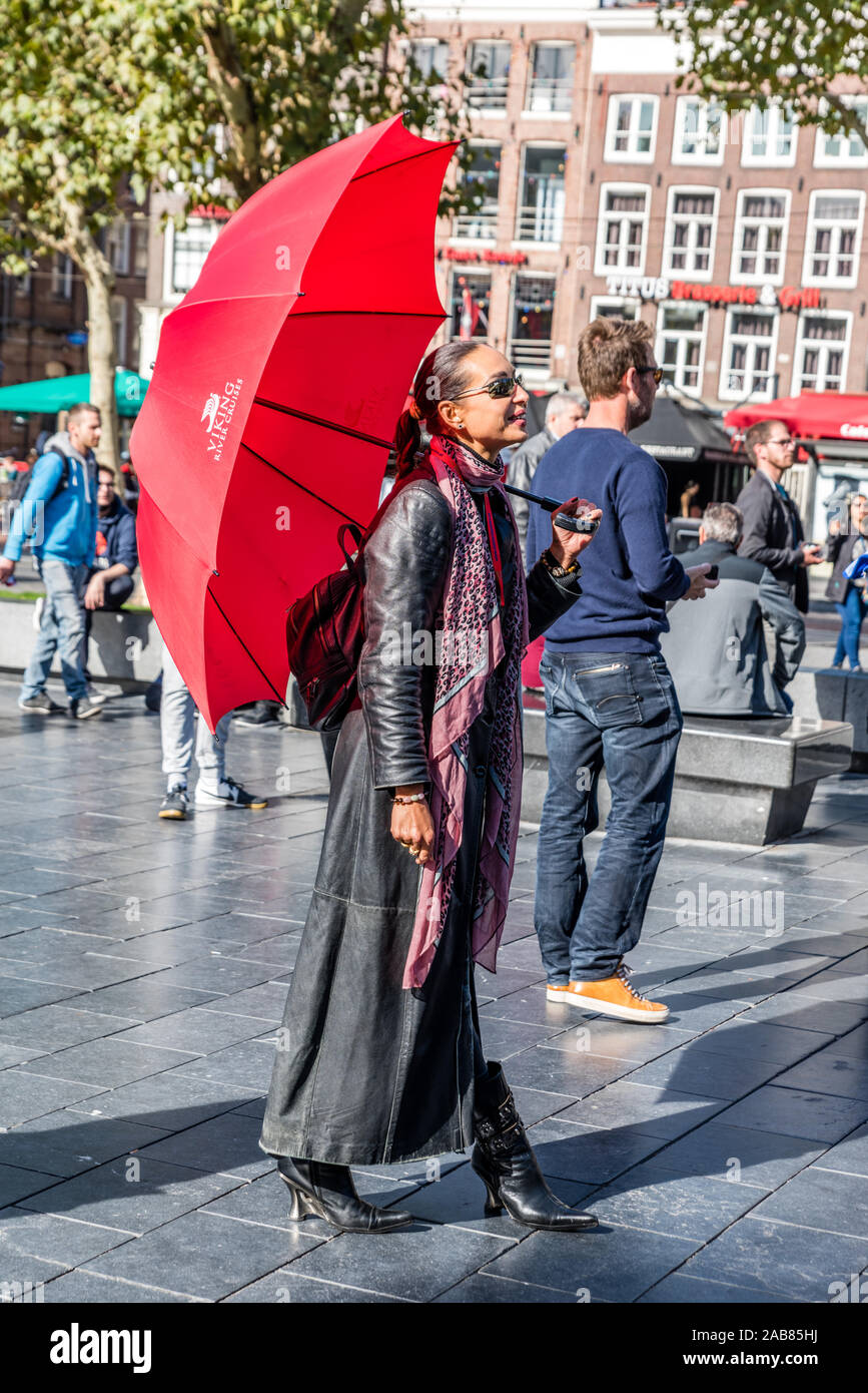 Amsterdam, Hollande, septembre 2018 un trop grand nombre de touristes qui  visitent la ville de preuves d'Amsterdam cette longue femme guide avec  parapluie rouge et cuir long j Photo Stock - Alamy