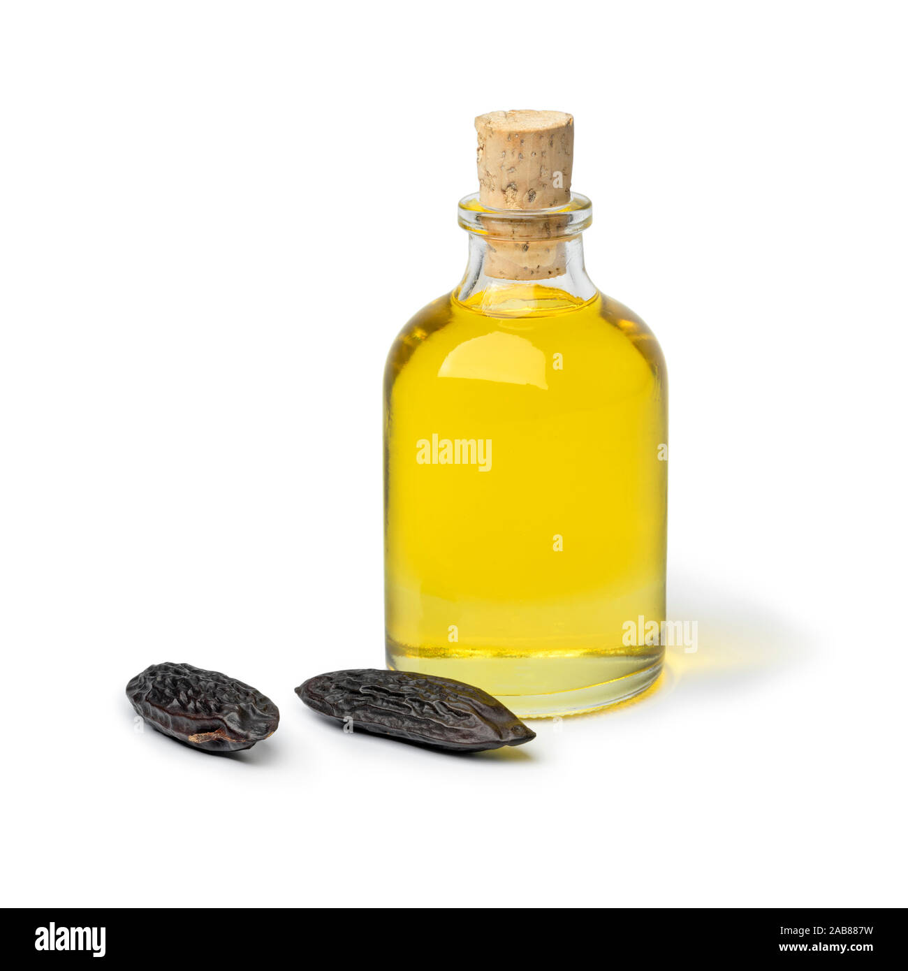 Bouteille de verre et d'huile de fève de Tonka fèves tonka entière isolé sur fond blanc Banque D'Images