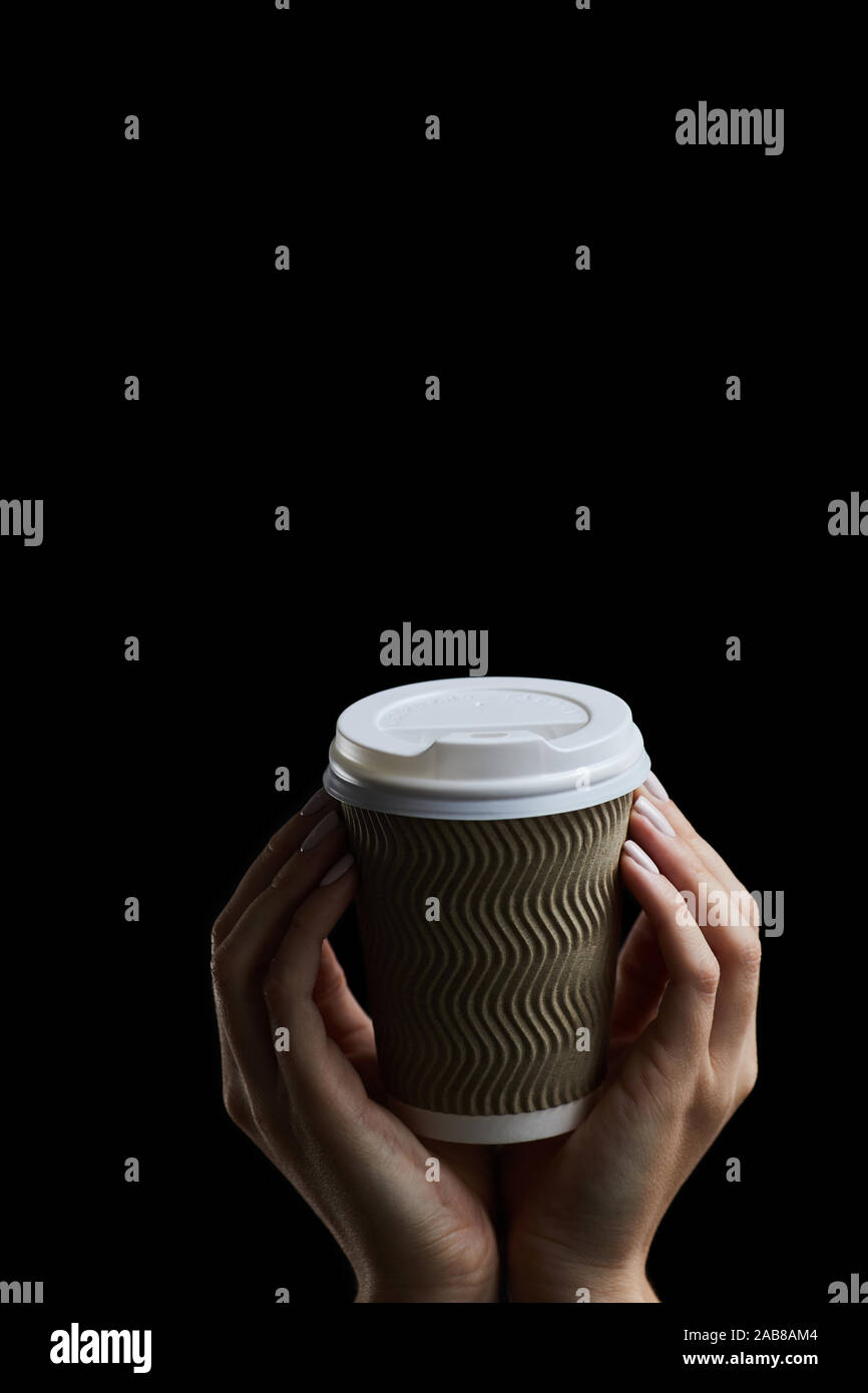 Maquette de femme main tenant un café tasse de papier sur fond sombre. L'espace de bannière des maquettes pour l'ajout de texte Banque D'Images