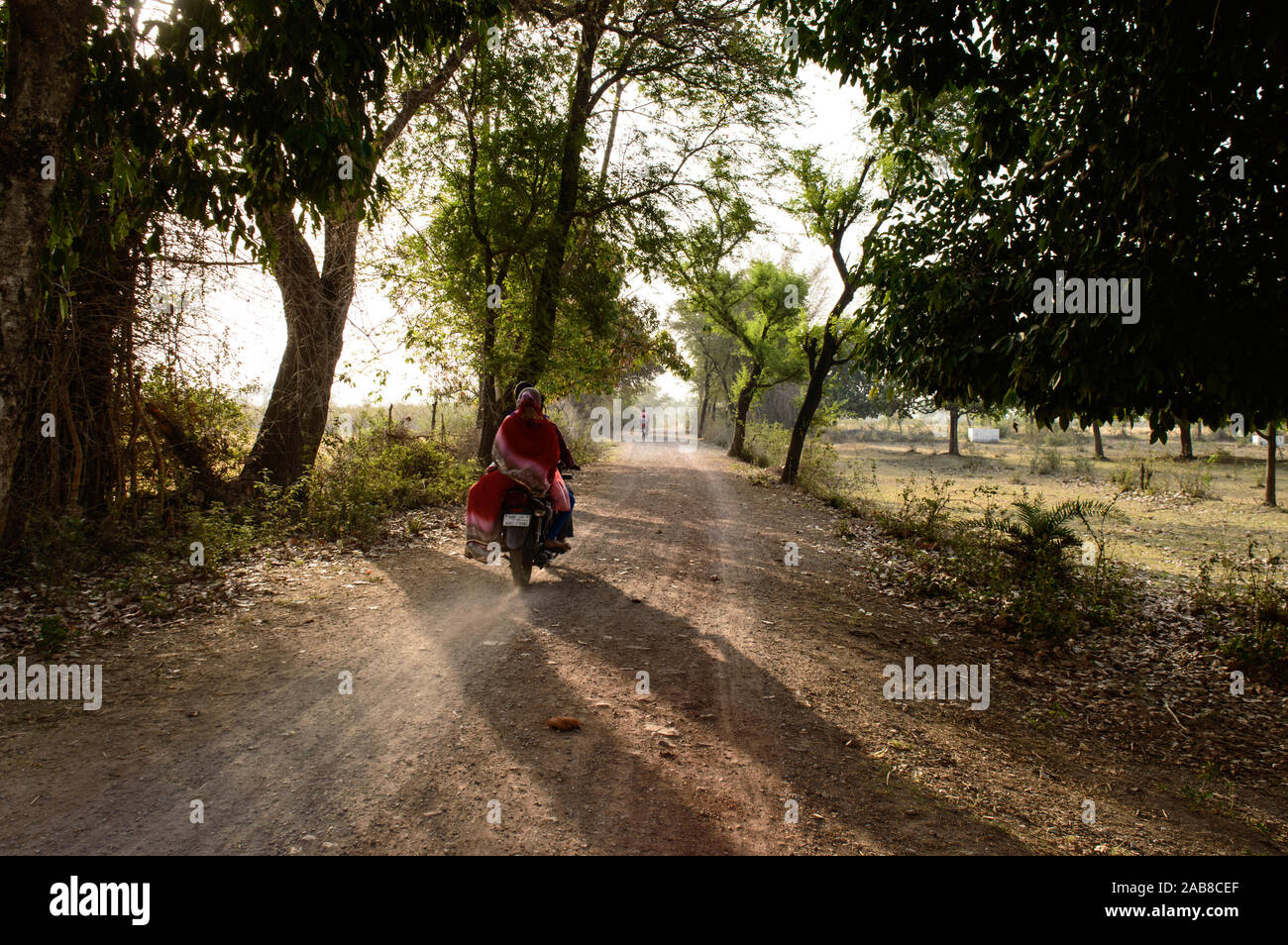 Villageois indien avec sa femme va acheter des serviettes neuves pour son fils sur la moto les jours d'été. Banque D'Images