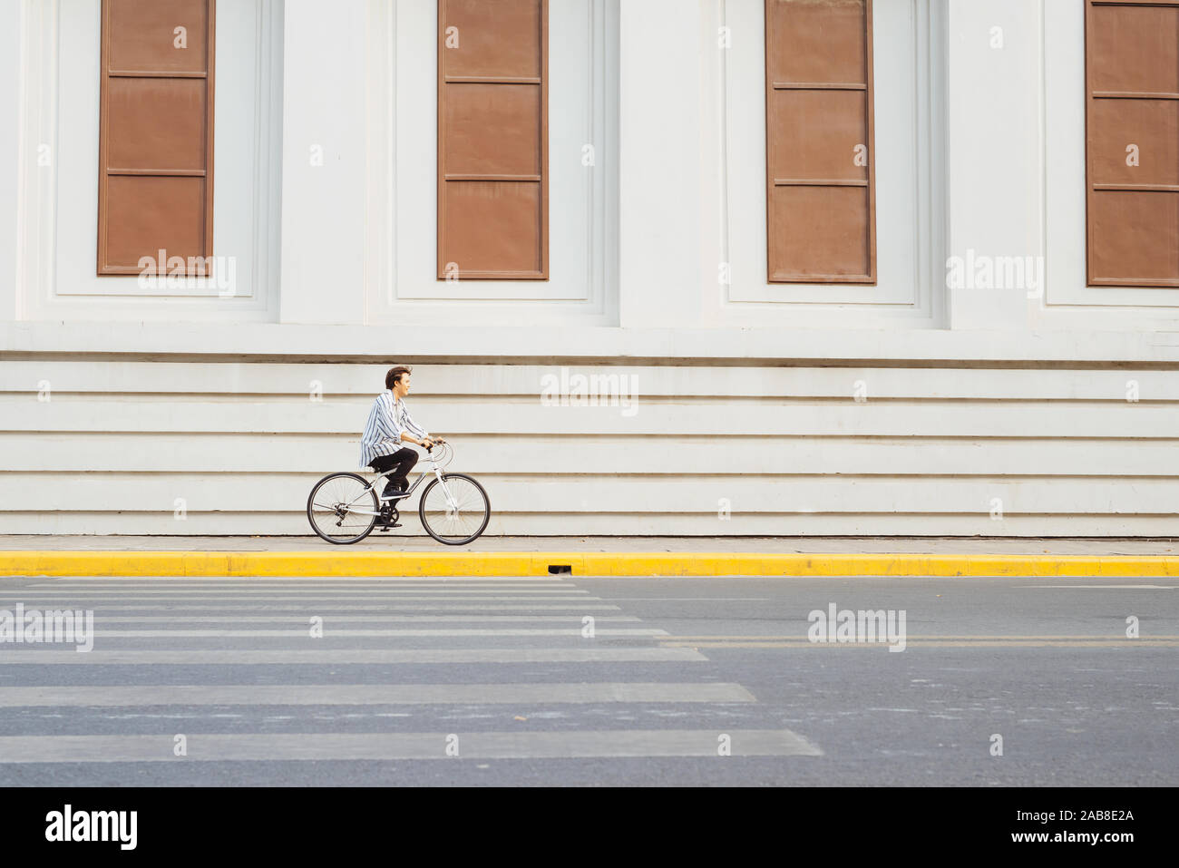 Passe partout par son vélo. Vue latérale du jeune homme d'affaires à l'avant en roulant sur son vélo Banque D'Images