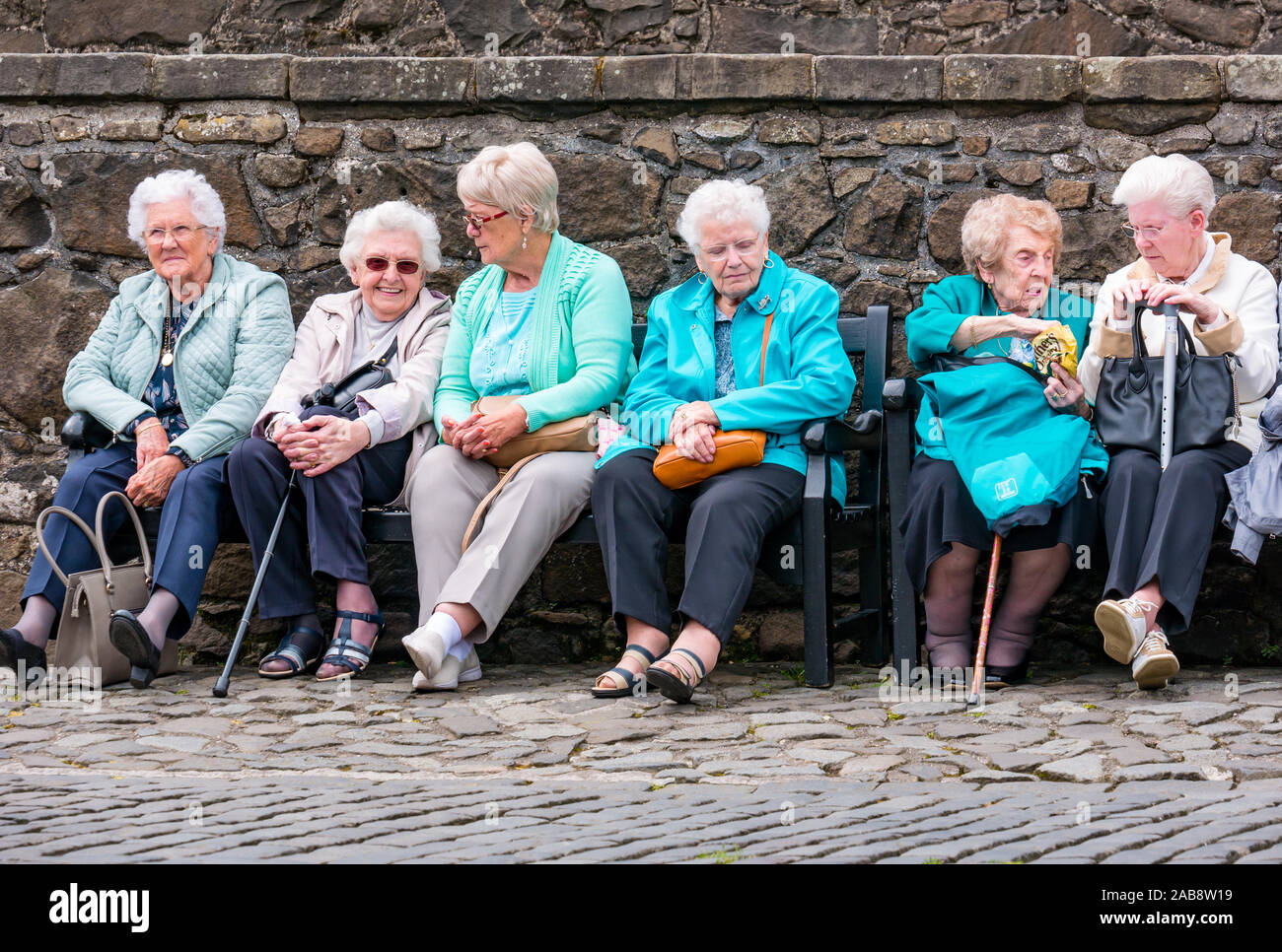Groupe des femmes âgées, assis sur un banc sur une sortie journée, le château de Stirling, Scotland, UK Banque D'Images