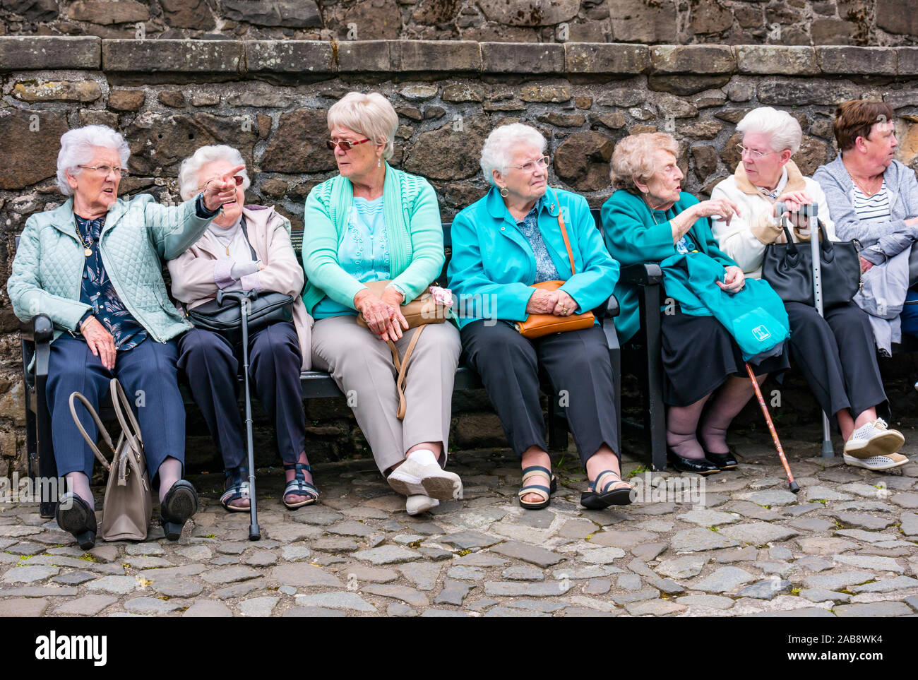 Groupe des femmes âgées, assis sur un banc sur une sortie journée, le château de Stirling, Scotland, UK Banque D'Images