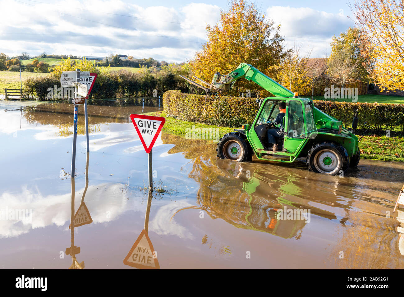 Chargeur chariot roulant dans l'eau de l'inondation de la rivière Severn couvrant les voies dans le village de Vale de Severn Chaceley, Gloucestershire UK 18/11/2019 Banque D'Images