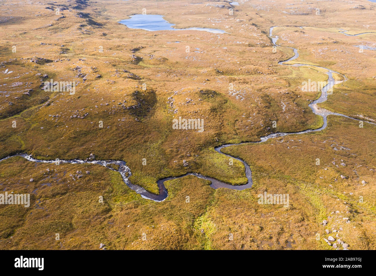 Drone de haute altitude sur la tige à travers la lande pittoresque rivière sinueuse dans le nord-ouest des Highlands d'Écosse - NC500 Vélo Banque D'Images