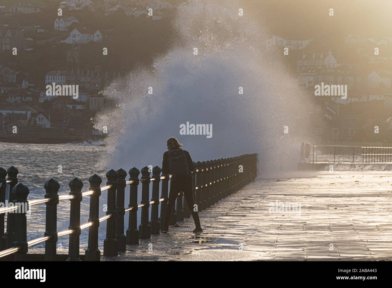 Penzance, Cornwall, UK. 26 novembre 2019. Météo britannique. Un photographe dés avec le danger d'essayer de saisir des images de l'énormes vagues qui se fracassent sur le front de mer à Penzance que storm Sébastien pousse des vagues énormes à l'intérieur des terres. Beaucoup de Cornwall est sur alerte aux crues torrentielles avec pluie prévue pour plus tard. Maycock / AlamyLive Simon crédit News. Banque D'Images