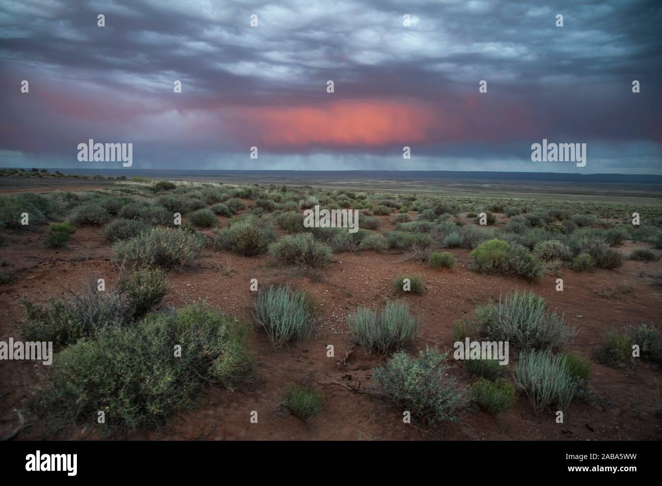 La lumière d'un soleil couchant jette ses couleurs sur les nuages d'un autre orage dans le Nord de l'Arizona. Banque D'Images