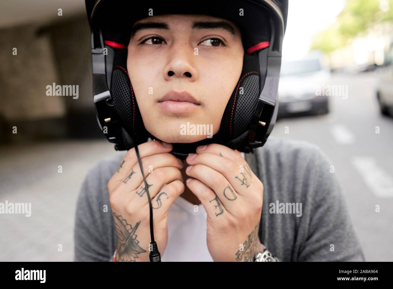 Young Asian man man putting on helmet Banque D'Images