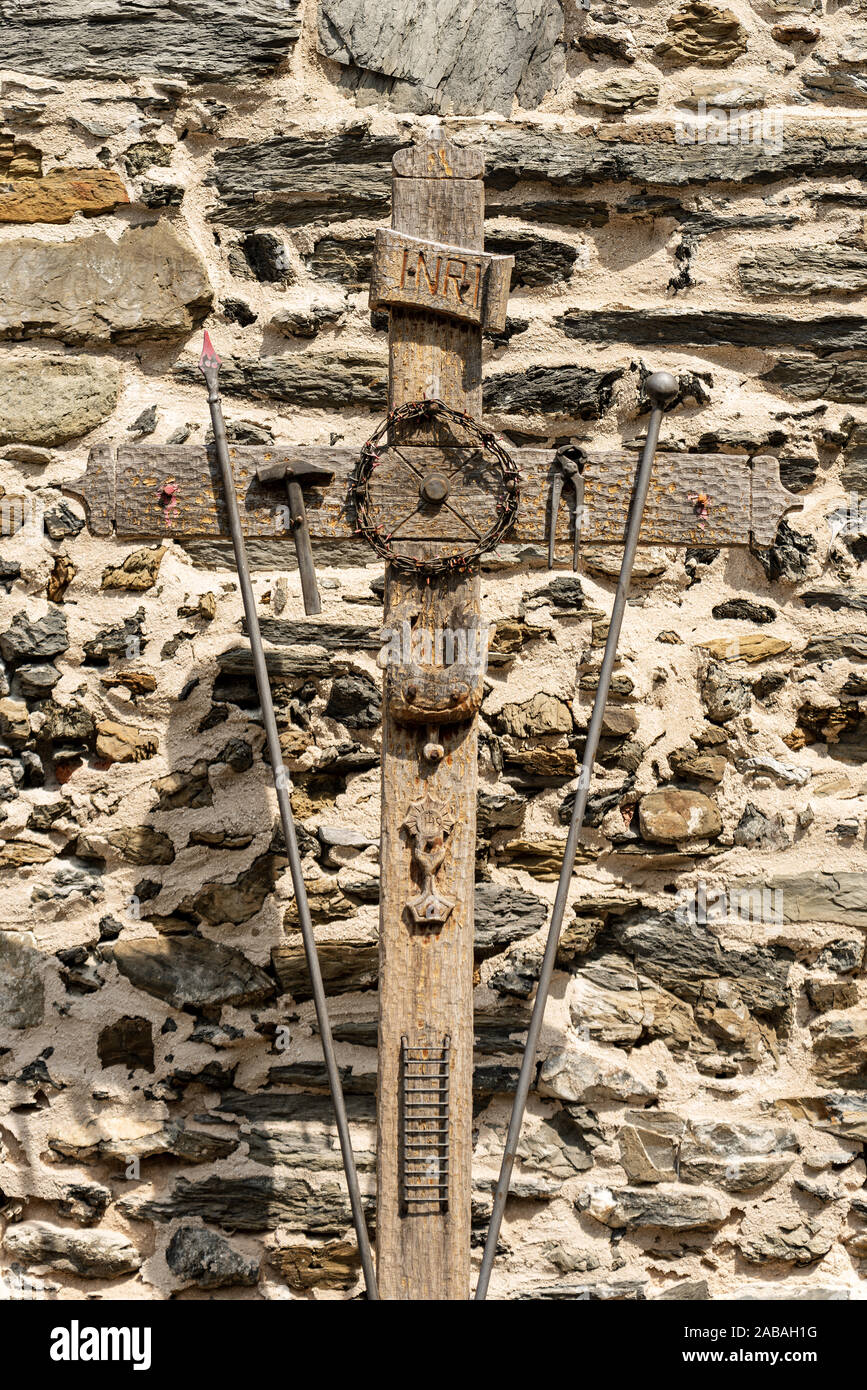 Croix avec les symboles de la Passion du Christ, en pince, échelle, marteau, calice, lance, couronne d'épines, coq, INRI texte. Village de Vernazza, Italie Banque D'Images