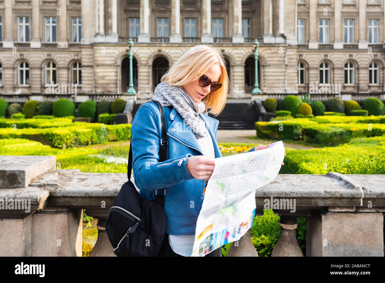 Une femme lit un plan de ville sur fond de Palais Royal de Bruxelles, Belgique Banque D'Images