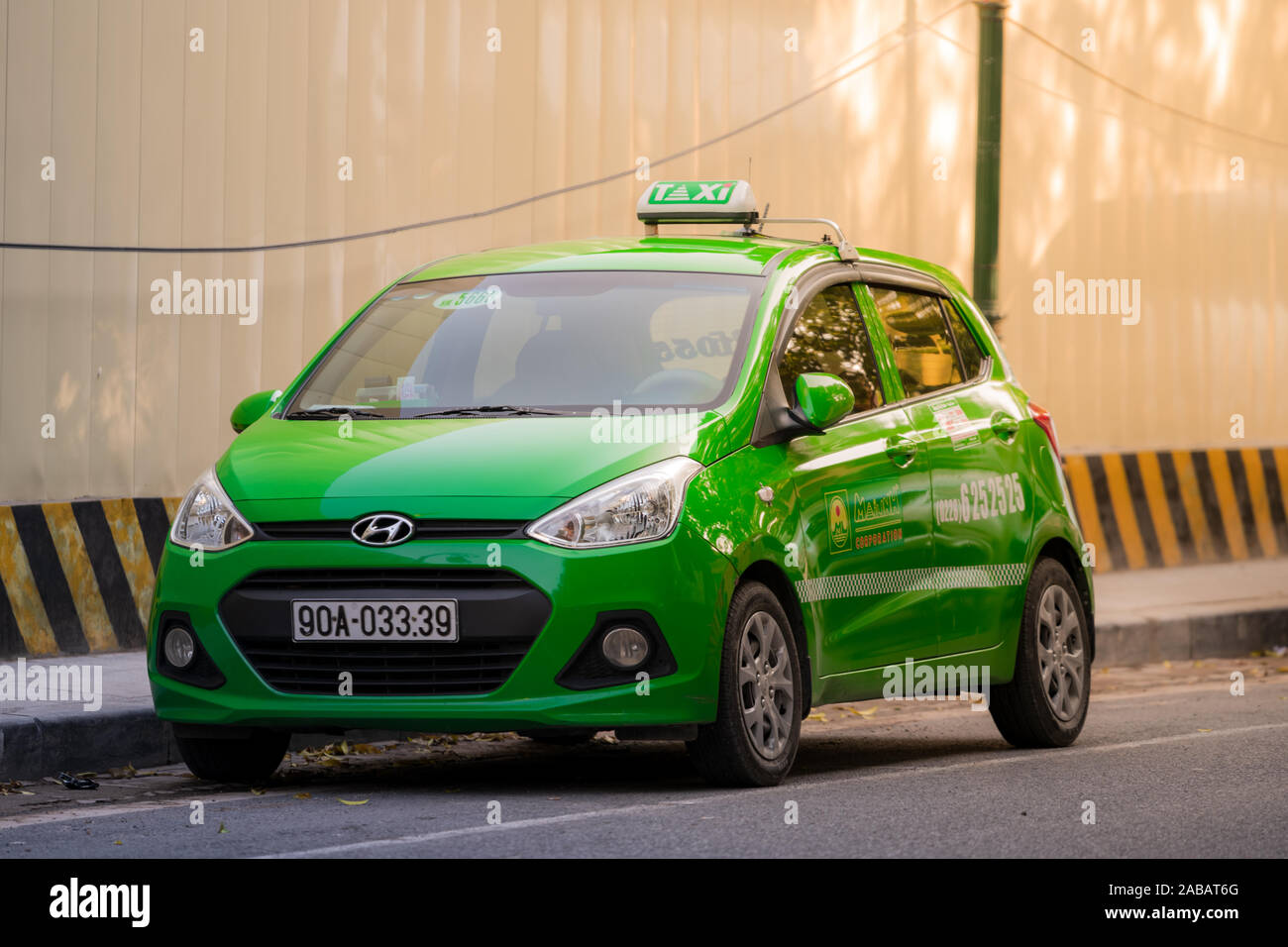 Hanoi, Vietnam - 11 octobre 2019 : une Hyundai i10 Mai Linh taxi vert se trouve dans les rues de Hanoi en attente d'un client pendant le coucher du soleil Banque D'Images