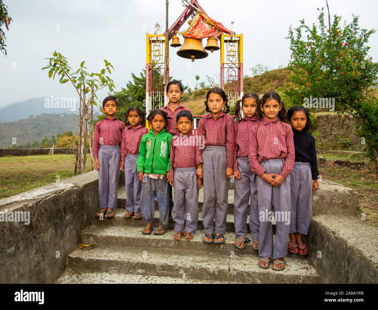 Les enfants de Sanouli village sur l'uniforme scolaire posant devant la porte du temple, Sanouli, Uttarakhand, Inde Banque D'Images