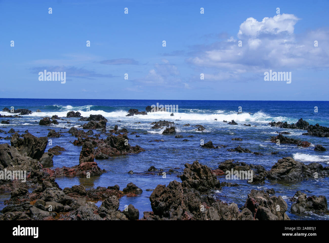 L'océan bleu (mer) et blanc vagues se brisant sur les rochers sur la côte rocheuse de l'île de Pâques. Banque D'Images