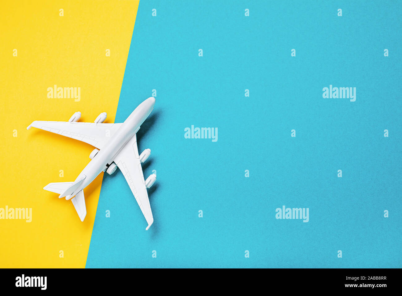 Un petit avion jouet blanc sur un fond de papier avec une copie de l'espace. Concept de billet et le transport aérien, vue du dessus Banque D'Images