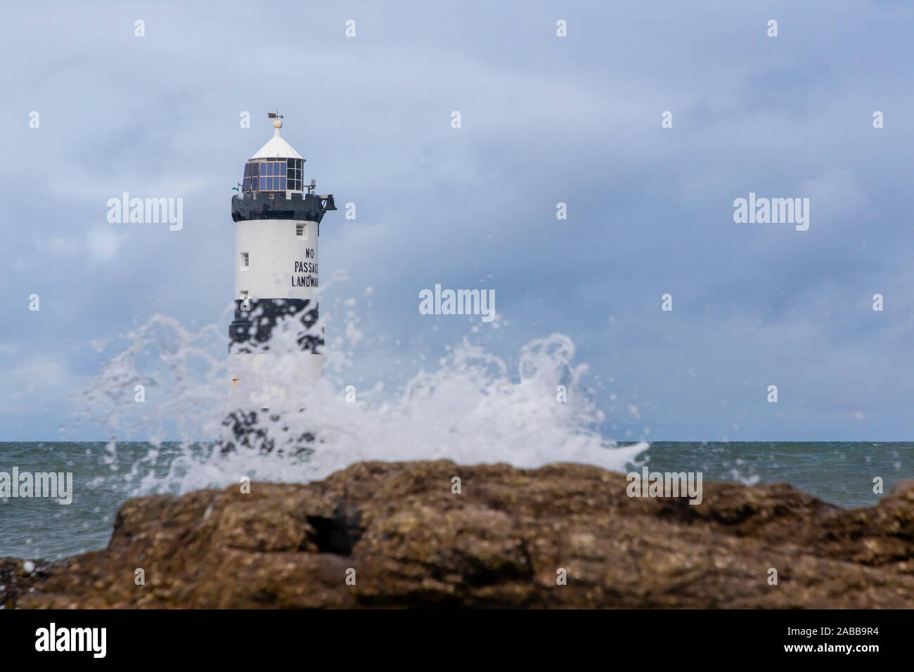 Penmon Lighthouse (Phare) * 1963 : ouverture intégrale du sur l'extrémité orientale d'Anglesey, dans le Nord du Pays de Galles, avec des vagues se brisant sur les roches Banque D'Images