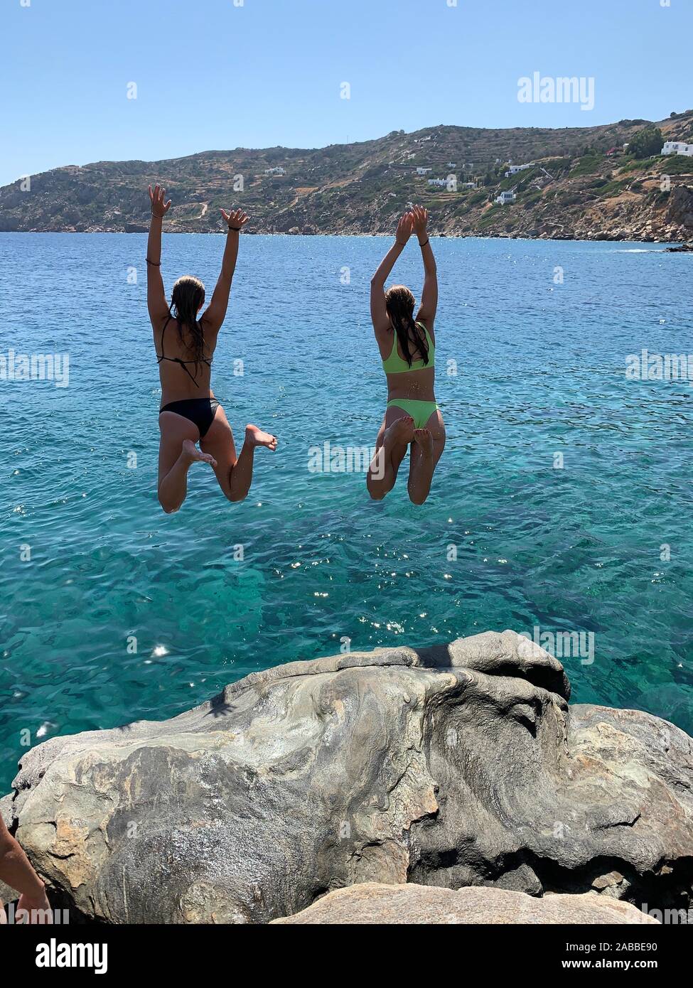 Deux jeunes filles sautant en mer, Grèce Banque D'Images