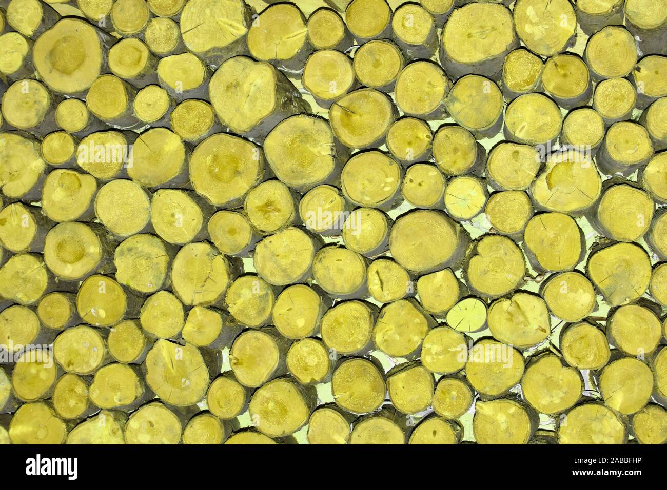 Motif de fond abstrait manipulé image couleur jaune appliquée aux extrémités de petites longueurs diamètre empilés au hasard ronde sciage sciage England UK Banque D'Images