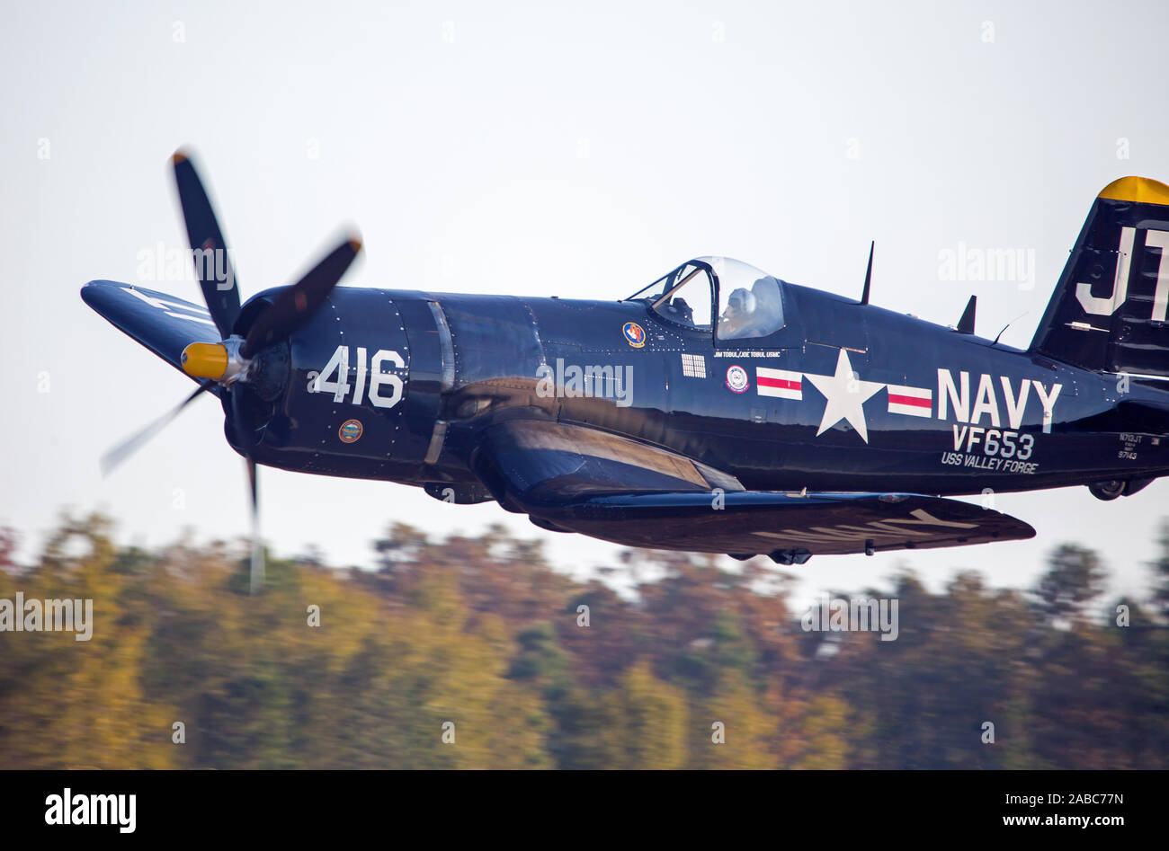 MONROE, NC (USA) - 9 novembre 2019 : Un Vought F4U Corsair un avion de chasse vole au niveau de la cime des arbres au cours de l'Warbirds sur Monroe Air Show. Banque D'Images