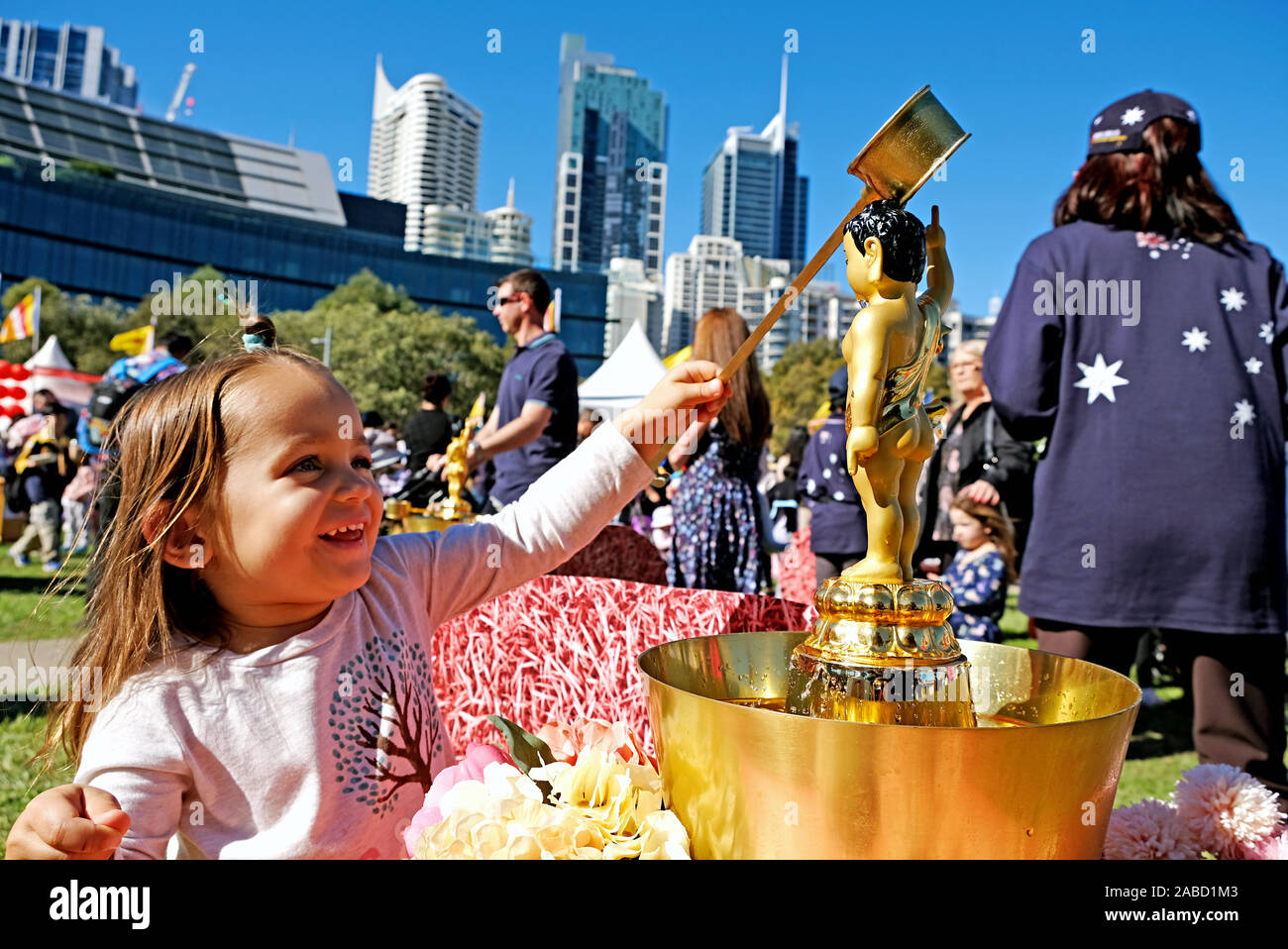 12 mai 2019 - Sydney, Australie : la naissance de Bouddha Festival multiculturel à l'audace du port. Une jeune fille est heureuse de donner un bain Buddha statue Banque D'Images