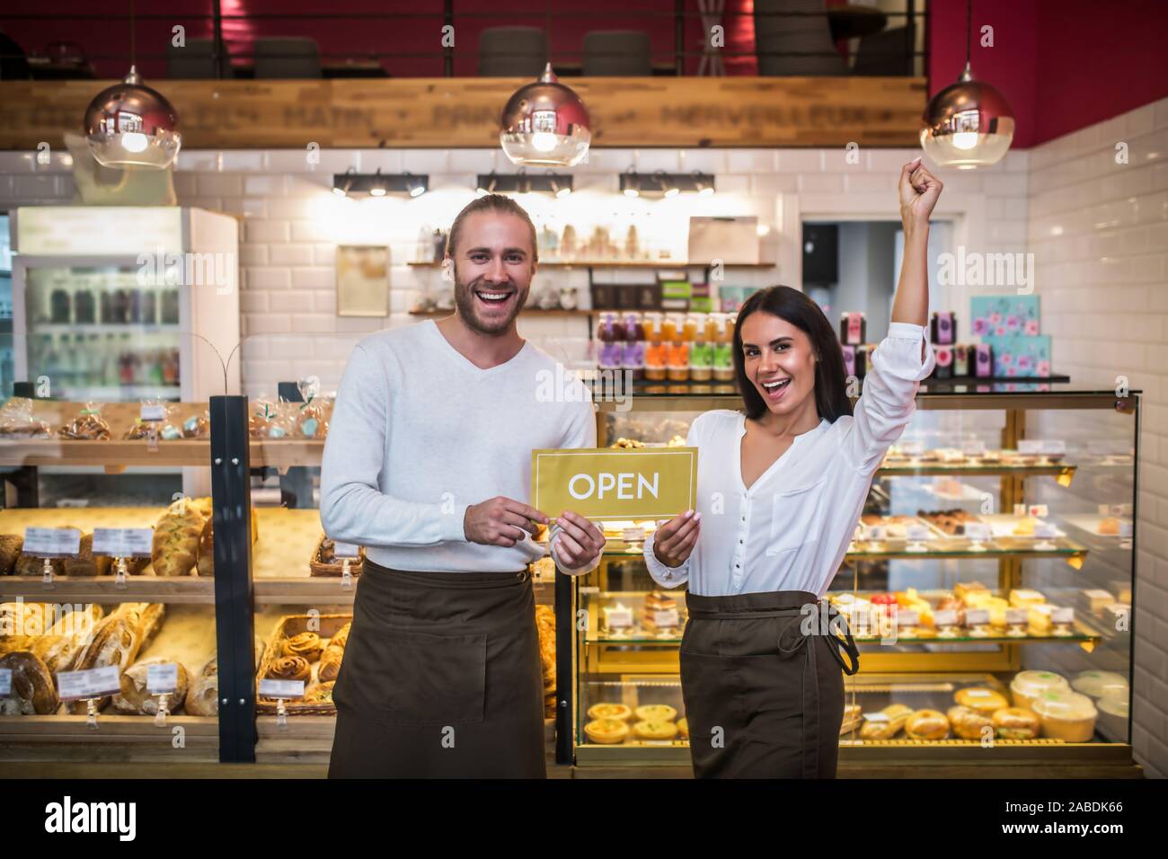 Cheerful couple se sentir vraiment heureux pendant l'ouverture de leur propre boulangerie Banque D'Images