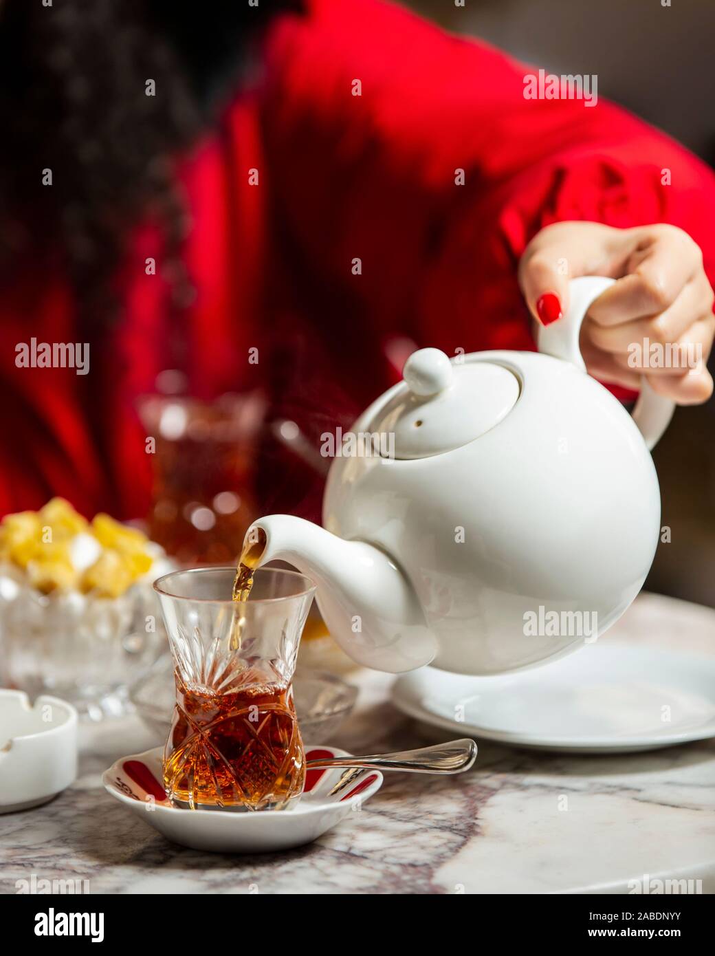 Woman pouring thé noir de théière en verre armudu Banque D'Images
