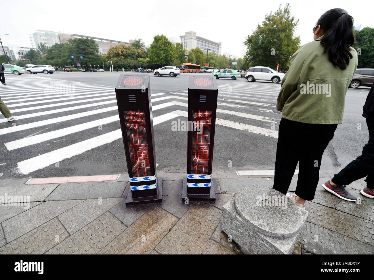 Les gens attendent pour les feux rouges pour traverser le passage piétons dans une rue de la ville de Luoyang, province du Henan en Chine centrale, 10 octobre 2019. Banque D'Images