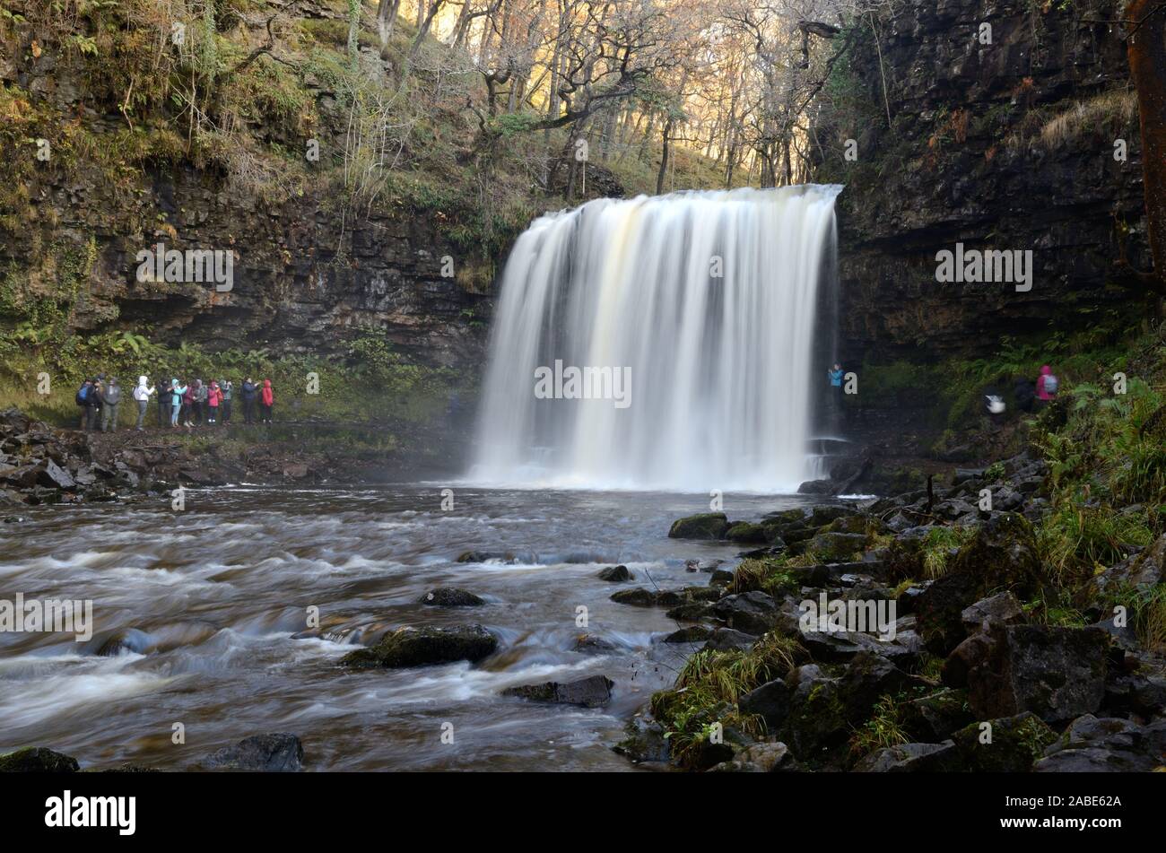 Les touristes à la recherche de personnes à Sgwd yr Eira cascade sur la rivière Afon Mellte Ystradfellte Pontneddfechan Parc national de Brecon Beacons Fforest Fawr Geopark Banque D'Images